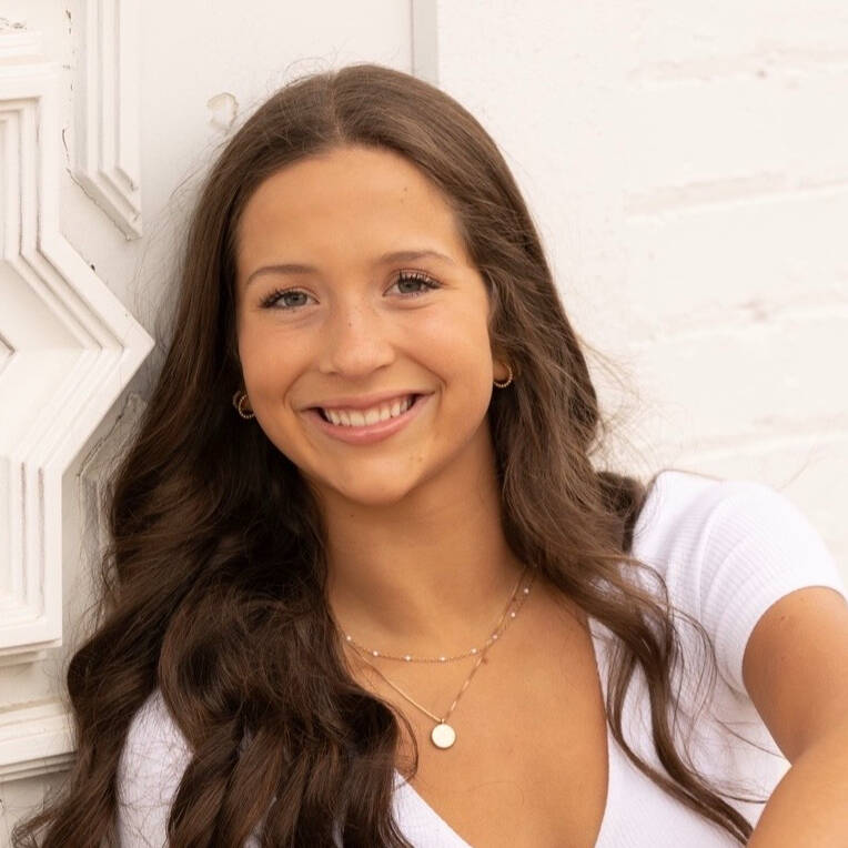 Smiling young brunette woman against a white background